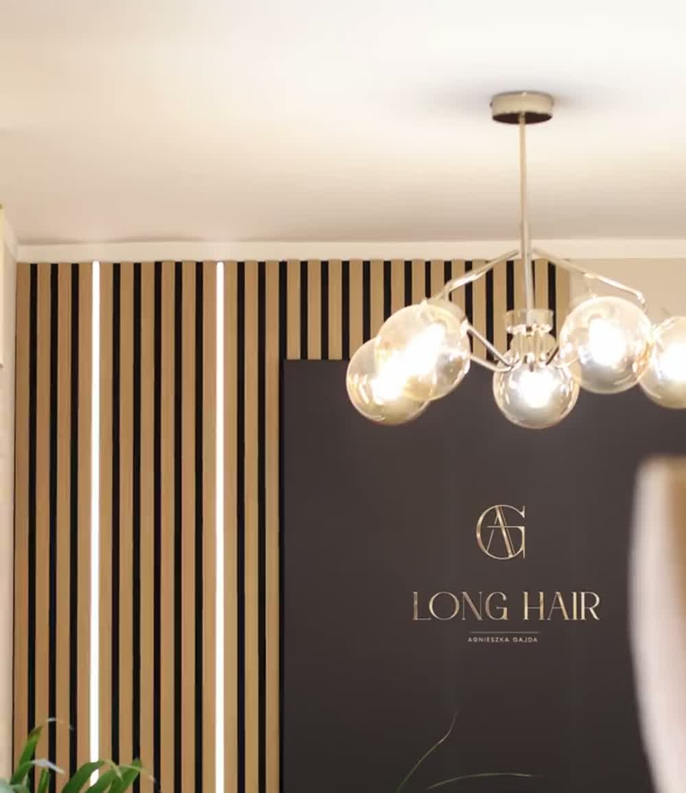 Drewniane lamele, złote detale i logo w rzeczywistym wnętrzu salonu LONG HAIR